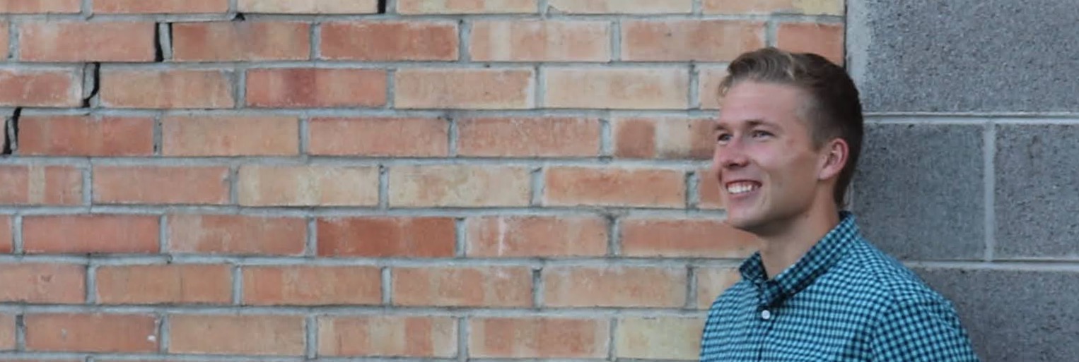 Picture of Kamryn leaning up agains a brick wall and smiling